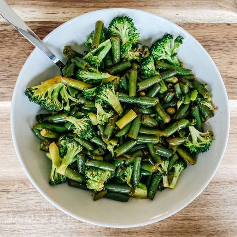 Broccoli and green bean stir fry in a white bowl