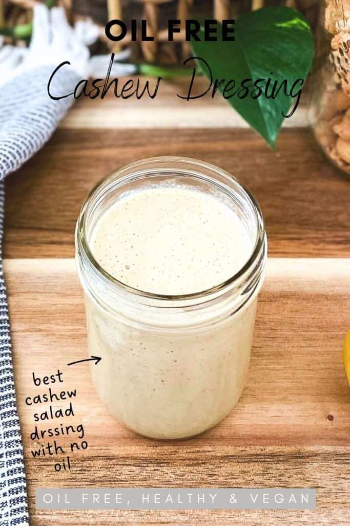 Oil free cashew dressing in a glass mason jar on a wood chopping board.