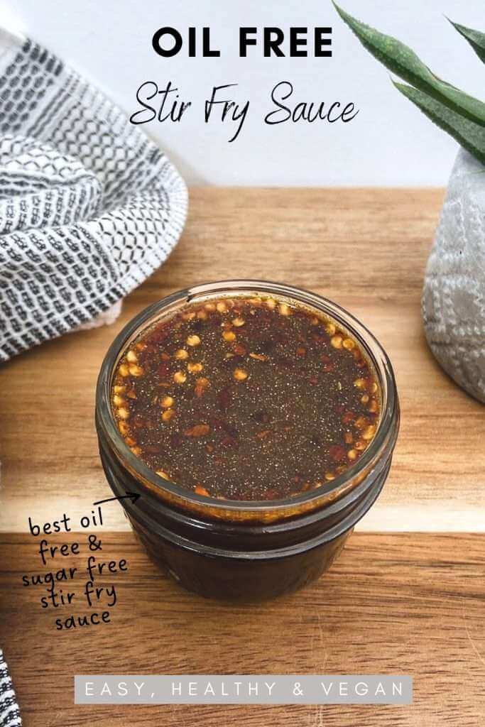 Oil free and sugar free stir fry sauce in a glass mason jar on a wood chopping board. Text on image says oil free stir fry sauce, best oil free and sugar free stir fry sauce - easy, healthy & vegan