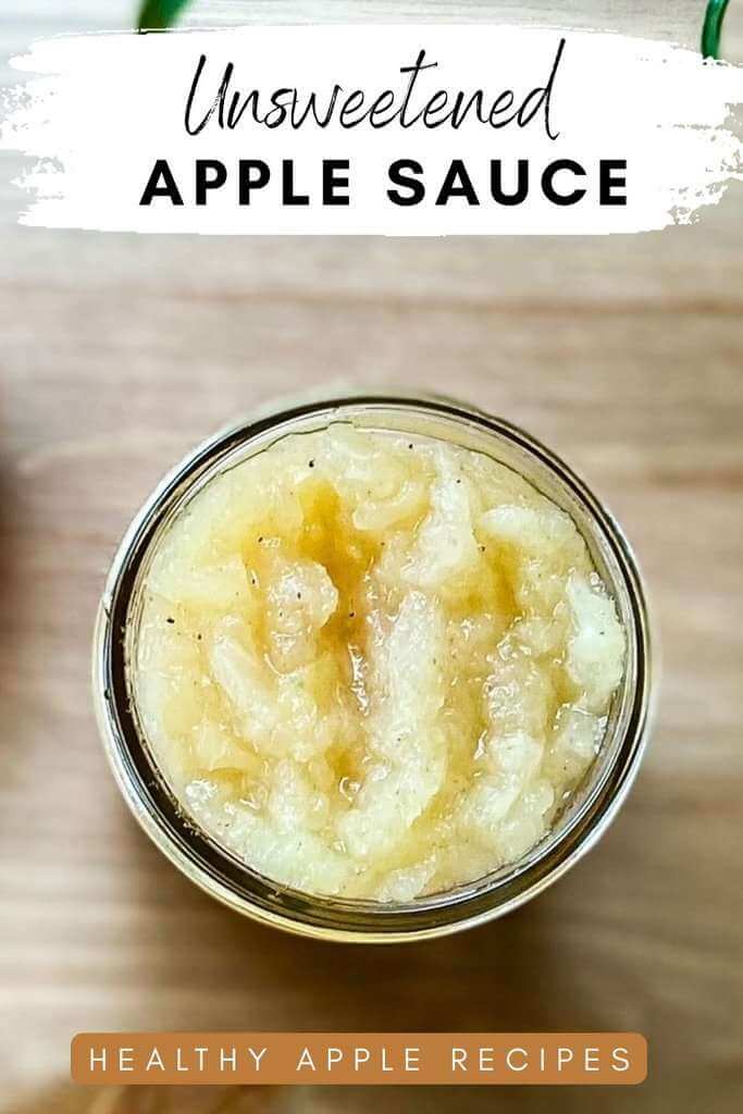 Unsweetened applesauce in a glass jar on a wooden surface.